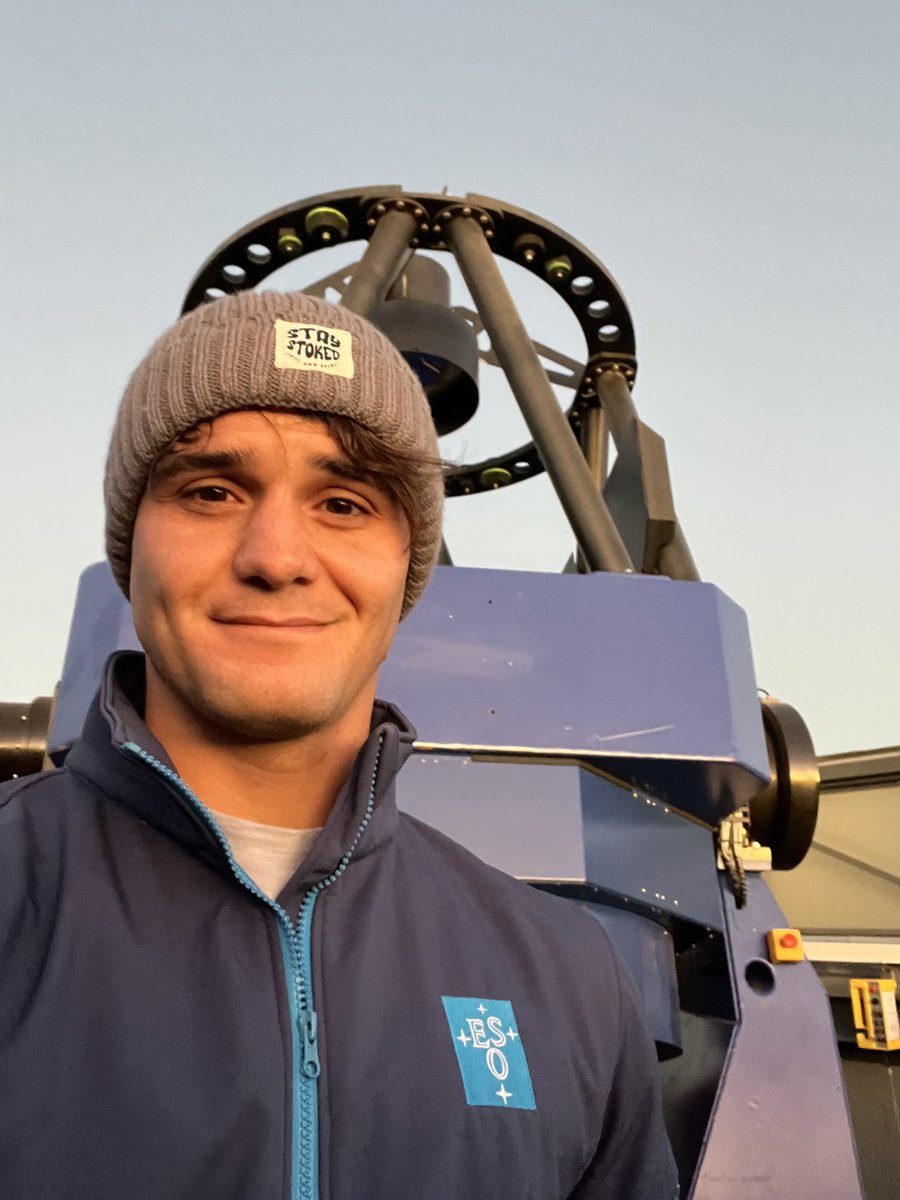 Enzo smiling in front of a telescope at dusk
