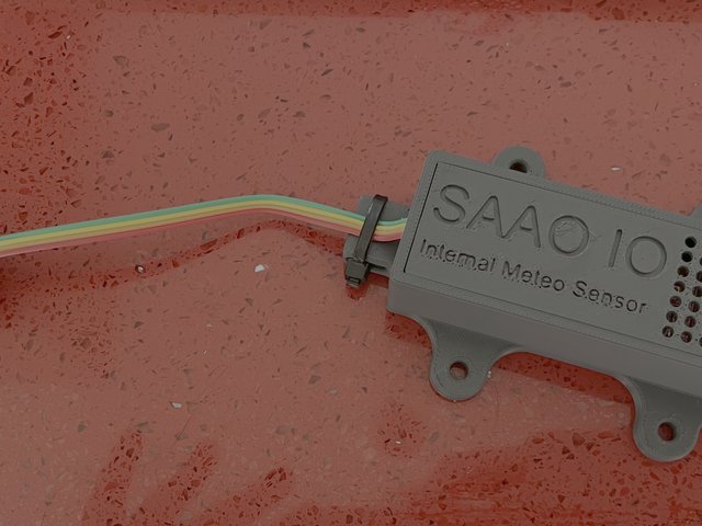 A 3D-printed grey sensor node with the SAAO IO logo on its lid